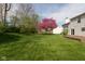 Large backyard boasts a lush lawn, mature trees, and a deck, perfect for relaxation at 6075 Bristlecone Dr, Fishers, IN 46038