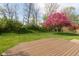Beautiful backyard with a well-maintained lawn, wood deck, and flowering tree at 6075 Bristlecone Dr, Fishers, IN 46038