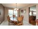 Bright dining room with natural light, wooden table set, neutral walls, and elegant chandelier at 6075 Bristlecone Dr, Fishers, IN 46038