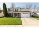 Charming two-story home with brick accents, a manicured lawn, and a two car garage on a sunny day at 6075 Bristlecone Dr, Fishers, IN 46038
