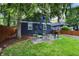 This backyard features an outdoor dining set and grill situated on a patio in a green lawn at 6106 Evanston Ave, Indianapolis, IN 46220