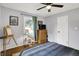 Cozy bedroom featuring light gray walls, hardwood floors, a ceiling fan, and natural light from the outdoor view at 6106 Evanston Ave, Indianapolis, IN 46220