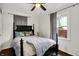 Well-lit bedroom boasts a black, four-poster bed with decorative pillows and blanket, hardwood floors and bright window at 6106 Evanston Ave, Indianapolis, IN 46220
