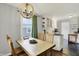 Well-lit dining area with a modern light fixture, hardwood floors, and an adjacent kitchen space at 6106 Evanston Ave, Indianapolis, IN 46220