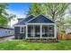 Charming home with a screened porch, blue siding, and well-maintained landscaping at 6106 Evanston Ave, Indianapolis, IN 46220