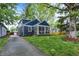 Two-story home featuring blue siding, a screened porch, and a long driveway at 6106 Evanston Ave, Indianapolis, IN 46220