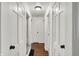 Hallway featuring hardwood flooring, white doors, and classic design elements at 6106 Evanston Ave, Indianapolis, IN 46220