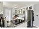 Bright kitchen featuring stainless steel appliances, granite countertops, and white cabinetry with glass fronts at 6106 Evanston Ave, Indianapolis, IN 46220