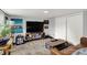 A modern living area showcasing a large TV, decorative posters, a retro-inspired media cabinet and a leather sofa at 6106 Evanston Ave, Indianapolis, IN 46220