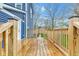 View of a spacious wooden deck with railings and a blue house with a door visible in the background at 614 Park Ave, Anderson, IN 46012