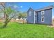 A spacious backyard with a wooden deck, lush green grass, a privacy fence, and a blue house exterior at 614 Park Ave, Anderson, IN 46012