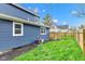 Side view of a blue house exterior and a green backyard with a wooden deck and a wooden fence at 614 Park Ave, Anderson, IN 46012