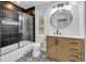 Bathroom with modern finishes, featuring a black-tiled shower, decorative patterned floors and a wood vanity at 614 Park Ave, Anderson, IN 46012