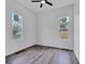Clean bedroom with modern wood-look floors, white walls, a ceiling fan and natural light from two windows at 614 Park Ave, Anderson, IN 46012