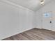 Versatile bonus room featuring shiplap walls, wood-look floors, modern light fixture and an exterior door at 614 Park Ave, Anderson, IN 46012