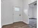 Bright entryway featuring wood-look flooring, a white front door with glass accents, and a view into another room at 614 Park Ave, Anderson, IN 46012