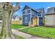 Charming blue two-story house with a bright yellow front door, complemented by a well-maintained lawn at 614 Park Ave, Anderson, IN 46012
