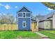 Charming two-story home showcasing a blue exterior, yellow door, manicured lawn, and freshly planted garden at 614 Park Ave, Anderson, IN 46012