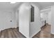 Hallway with wood-look flooring leads to the kitchen and features a white entry door at 614 Park Ave, Anderson, IN 46012