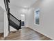 Hallway with a dark wood staircase leading to a bathroom with a blue vanity and modern fixtures at 614 Park Ave, Anderson, IN 46012