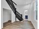 Bright hallway with hardwood floors, a black staircase, and bathroom access at 614 Park Ave, Anderson, IN 46012