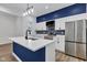 Modern kitchen with a blue accent wall, stainless appliances, and white cabinets at 614 Park Ave, Anderson, IN 46012