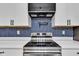 Close up view of the kitchen backsplash, oven, and vent hood at 614 Park Ave, Anderson, IN 46012