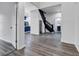 Inviting open-concept living space with modern wood-look flooring, a black staircase, and a glimpse of the kitchen at 614 Park Ave, Anderson, IN 46012
