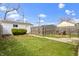 Large backyard featuring a grassy area, mature landscaping, privacy fence, and patio seating area at 6194 Evanston Ave, Indianapolis, IN 46220