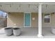 Close up of the covered porch, showing decorative planters, lighting, and the blue front door at 6194 Evanston Ave, Indianapolis, IN 46220