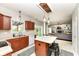 Open kitchen with an island, cherry cabinets, white appliances, and adjacent living room at 693 Prince Dr, Greenwood, IN 46142