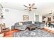 Inviting living room features a plush gray sectional, stylish ceiling fan, and rich wood flooring at 693 Prince Dr, Greenwood, IN 46142