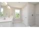Modern bathroom with double sink vanity, a tiled shower, and a bright window offering natural light at 7215 Barrett Dr, Brownsburg, IN 46112