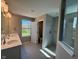 Bathroom featuring double sinks, a walk-in shower, and natural light from a window at 7215 Barrett Dr, Brownsburg, IN 46112