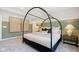 A bedroom has a large window and green and white walls and a modern canopy style bed at 7215 Barrett Dr, Brownsburg, IN 46112