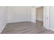 An empty bedroom with neutral walls, white trim, and gray wood-look floors with an open door at 7215 Barrett Dr, Brownsburg, IN 46112