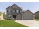 Charming two-story home with a three-car garage and manicured lawn at 7215 Barrett Dr, Brownsburg, IN 46112