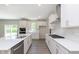 Modern kitchen with stainless steel appliances, white cabinetry, and island sink at 7215 Barrett Dr, Brownsburg, IN 46112