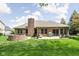 Expansive backyard featuring a brick firepit, patio, and well-maintained lawn at 7340 Stones River Dr, Indianapolis, IN 46259