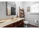 Bathroom with single vanity, decorative mirror, shelving over toilet, and modern fixtures for a calming aesthetic at 7340 Stones River Dr, Indianapolis, IN 46259