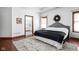 This main bedroom offers hardwood floors, a king bed, natural light, and an ensuite bathroom with a doorway view at 7340 Stones River Dr, Indianapolis, IN 46259