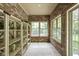 Charming sunroom with brick walls, shelving, tile floors, and natural light at 7340 Stones River Dr, Indianapolis, IN 46259