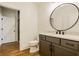 Modern bathroom featuring a round mirror, gray vanity, and stylish fixtures at 8082 Abington Way, Zionsville, IN 46077