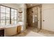 Luxurious bathroom featuring a soaking tub, glass-enclosed shower, and large windows offering an abundance of natural light at 8082 Abington Way, Zionsville, IN 46077