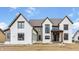 New construction home boasts painted brick, black trim windows and gabled roof against a cloudy blue sky at 8082 Abington Way, Zionsville, IN 46077