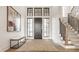 Elegant foyer with hardwood floors, a modern staircase, and a dark wood front door with transom windows at 8082 Abington Way, Zionsville, IN 46077