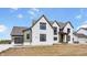 Exterior of a two-story home featuring a front porch with a wooden beam entryway and a gray shingle roof at 8082 Abington Way, Zionsville, IN 46077