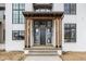 Inviting front porch with a wooden pergola, stone steps, and a dark wood door with sidelights at 8082 Abington Way, Zionsville, IN 46077