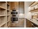 Modern kitchen with double ovens, built-in cabinetry, open shelving with LED lighting, and subway tile at 8082 Abington Way, Zionsville, IN 46077
