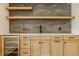 Modern kitchen with light wood cabinets, stylish backsplash, floating shelves, and stainless steel wine fridge at 8082 Abington Way, Zionsville, IN 46077